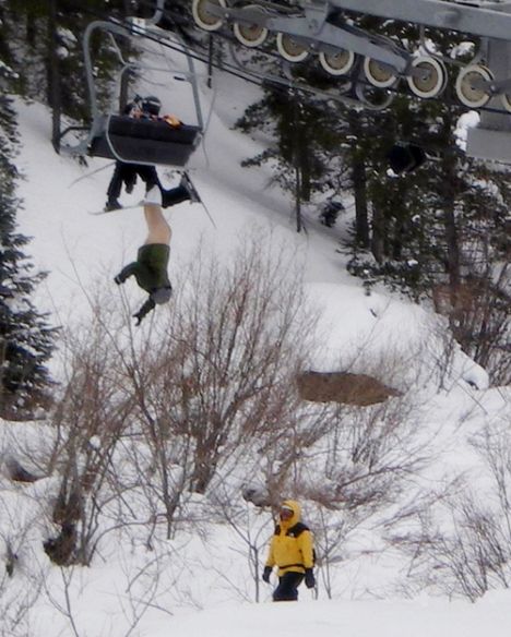 A man had a lucky escape but suffered a little more exposure than he would have wanted when he slipped through the back of a ski lift chair...He was left dangerously dangling upside down with his trousers and pants pulled down for all the world to see...It happened at the posh Vail resort in Colorado...It apparently occurred after the male skier and a child boarded a high-speed lift in Vail's Blue Sky Basin. It appears the chairlift's fold-down seat was somehow not in the lowered position, which caused the man to partially fall through the resulting gap. His right ski got jammed in the ascending chairlift, and that kept him upended since his boot never dislodged from its binding...As seen from photos taken by other skiers, the Skyline Express lift was stopped shortly after the pair's botched boarding resulted in the man dangling from the lift. The exposed skier was stuck for about 15 minutes before Vail personnel backed the lift up and successfully dislodged the unidentified man from the four-seat chair.